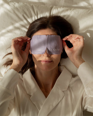 Self-Warming Eye Mask by LAMAV — woman lying down applying purple mask | relaxing sleep aid