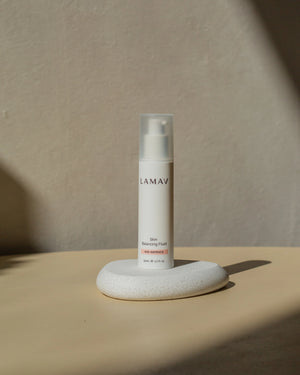 Skin Balancing Fluid by LAMAV — bottle resting on white stone | natural age-defying daily lotion
