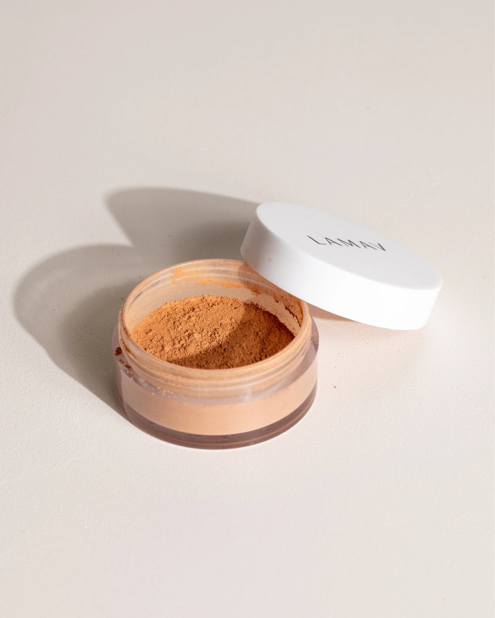 Sunkissed Bronzer by LAMAV — open jar with lid on beige backdrop | achieve a healthy bronzed look