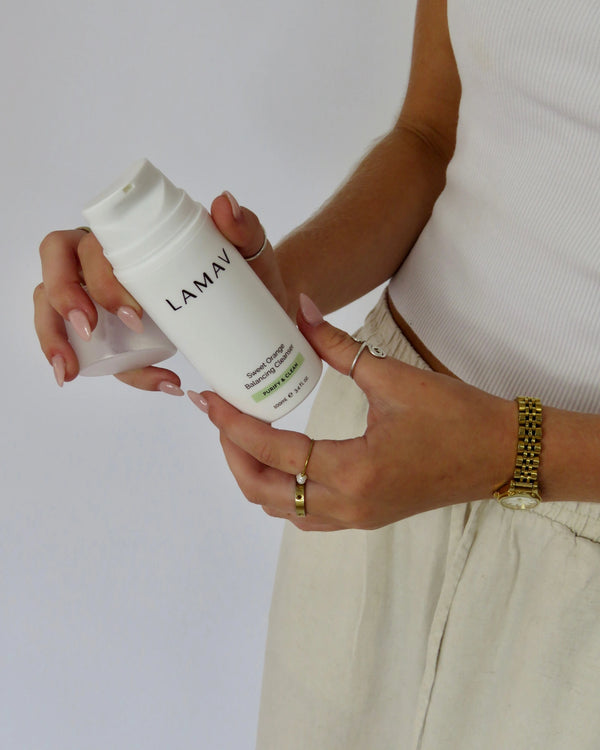 Sweet Orange Balancing Cleanser by LAMAV — woman holding bottle and removing cap | ready for daily cleanse
