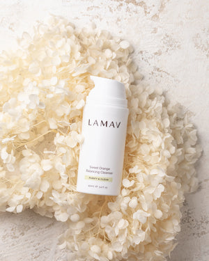 Sweet Orange Balancing Cleanser by LAMAV — bottle resting on white dried flowers | gentle organic botanical cleansing