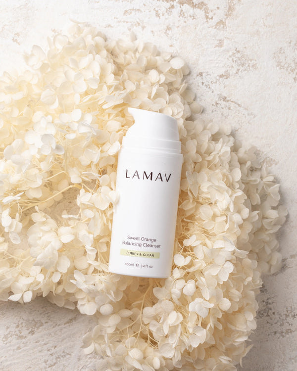 Sweet Orange Balancing Cleanser by LAMAV — bottle resting on white dried flowers | gentle organic botanical cleansing