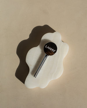 Tube Key by LAMAV — silver key resting alone on white wavy stone | durable reusable bathroom accessory