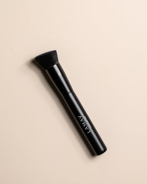 Vegan Foundation Brush by LAMAV — angled brush head resting on beige background | seamless streak-free coverage