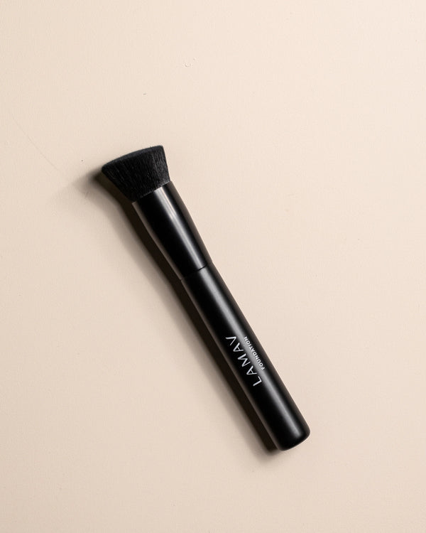 Vegan Foundation Brush by LAMAV — angled brush head resting on beige background | seamless streak-free coverage