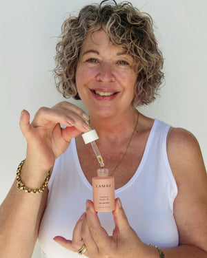 Vitamin A Repair Oil by LAMAV — smiling woman holding the serum dropper | promotes a youthful glowing complexion