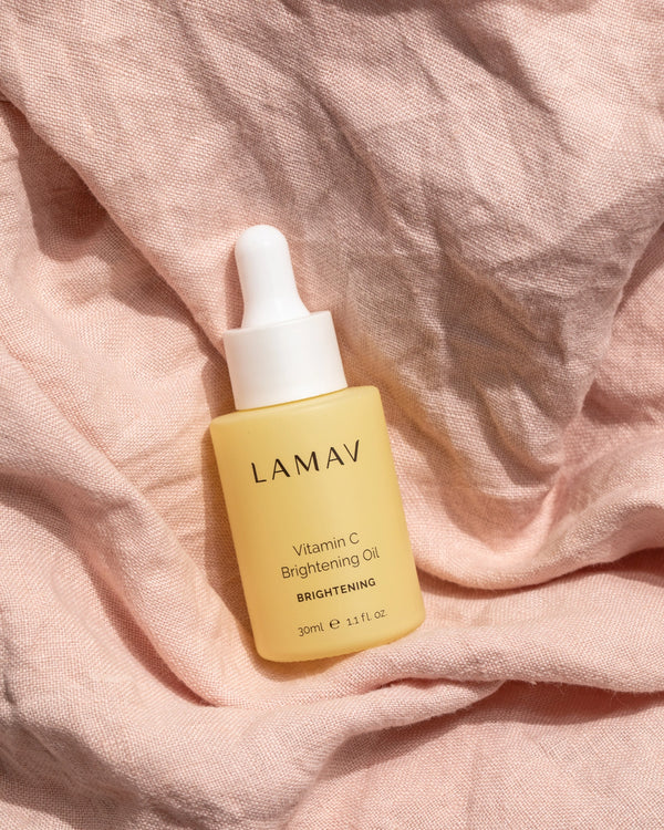 Vitamin C Brightening Oil by LAMAV — serum bottle styled on soft pink linen | antioxidant-rich facial treatment