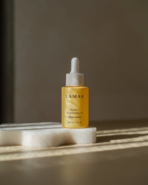 Vitamin C Brightening Oil by LAMAV — standing on a white stone in direct sunlight | brightens and evens skin tone