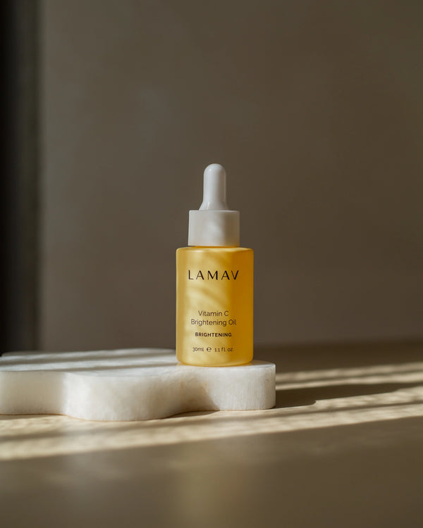 Vitamin C Brightening Oil by LAMAV — standing on a white stone in direct sunlight | brightens and evens skin tone
