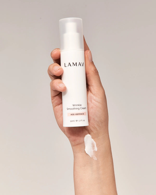 Wrinkle Smoothing Cream by LAMAV — hand holding bottle with cream swatch on wrist | rich and nourishing formula